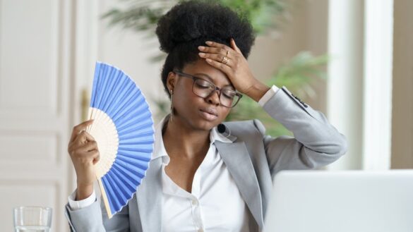 woman fanning herself in office