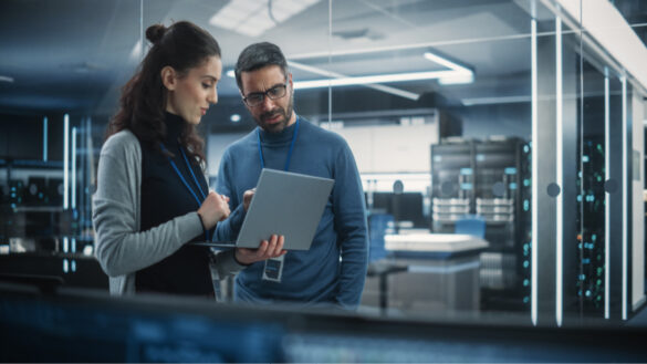 AI impact on jobs - TUC: Photo shows man and woman walking over a laptop