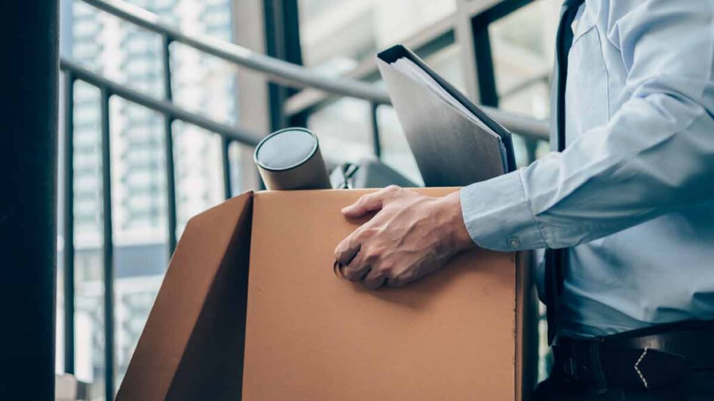 SME workers quit over return to office. Photo shows man carrying box out of office.