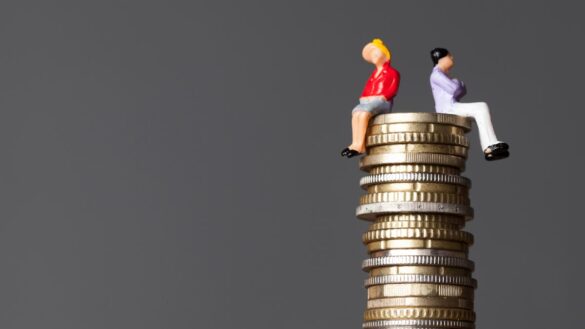 Equal pay questionnaires: image shows male and female figurines sitting atop a pile of coins.