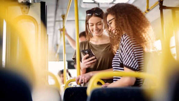 Free bus fares for under-22s. Photo shows two yound women travelling by bus.