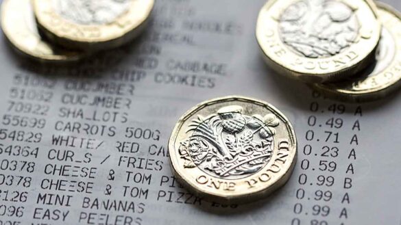 Inflation median pay deal. Photo shows pound coins on top of a till receipt.