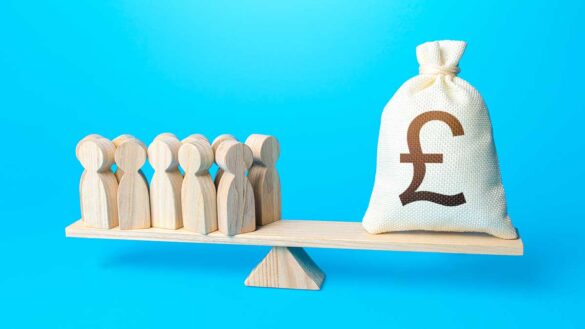 National living wage 2026 estimate. Image shows a bag of pound coins on a scale with a group of workers.